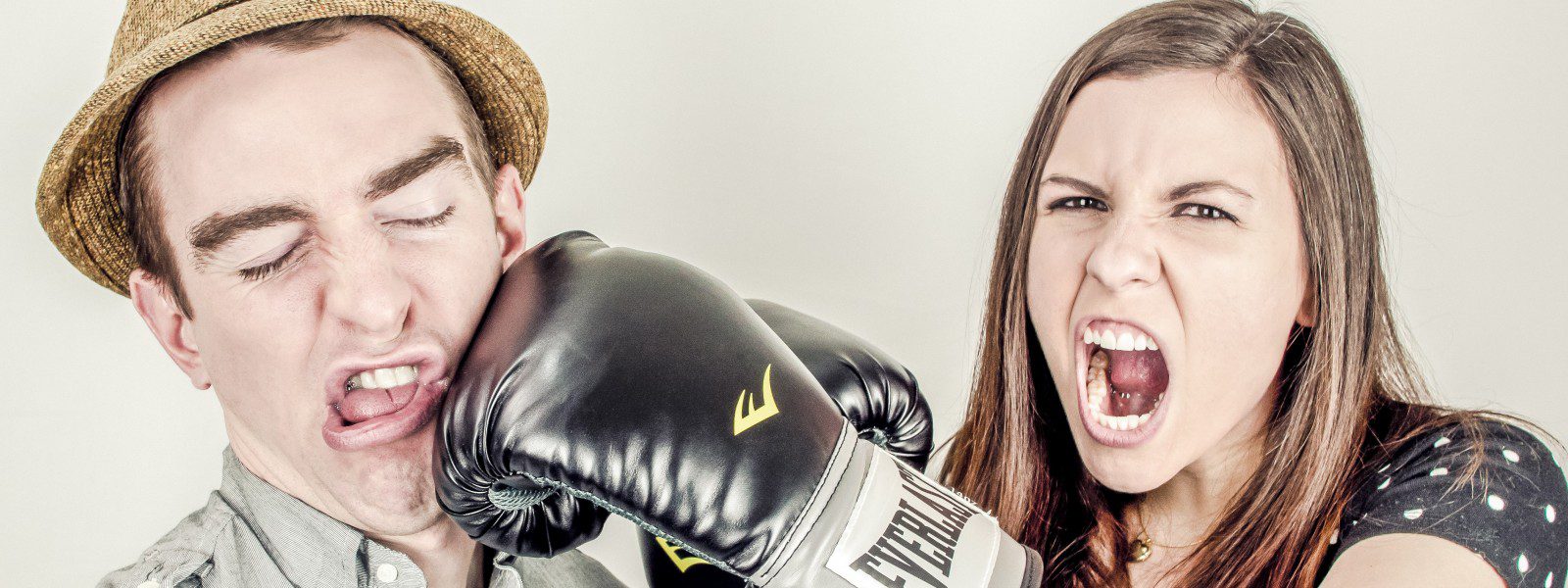 woman wearing boxing gloves punching a man