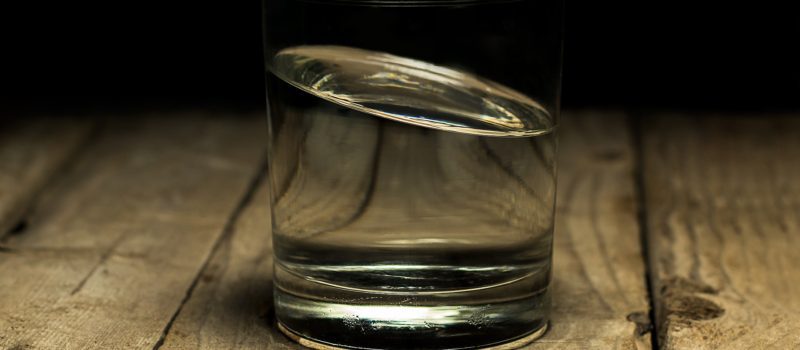 water in a glass cup and the water is tilted to the left